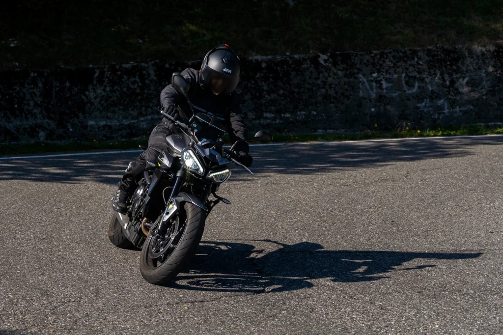 Fotografo moto sui passi in Lombardia 9 Foto in moto: motociclista su Triumph Street Triple nera in curva ai Colli di San Fermo (BG), 27 settembre 2026